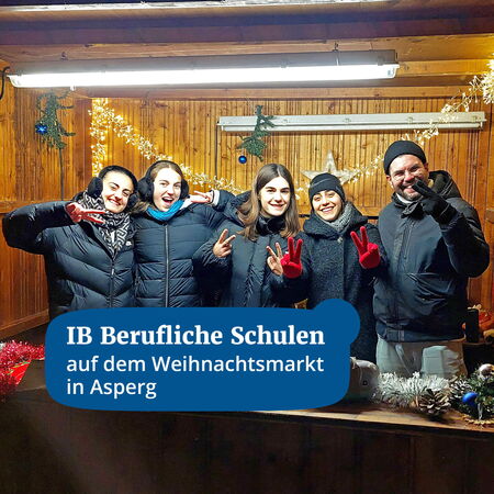 Eine Gruppe von fünf Personen lächelt und zeigt Friedenszeichen auf dem Weihnachtsmarkt in Asperg.