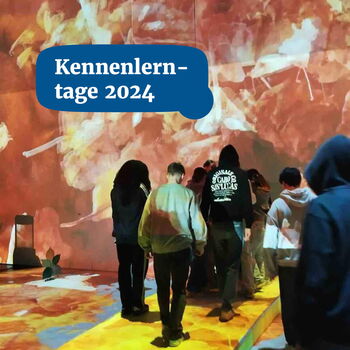 Eine Gruppe von Menschen erkundet eine immersive, farbenfrohe Projektion bei den Kennenlerntagen 2024.