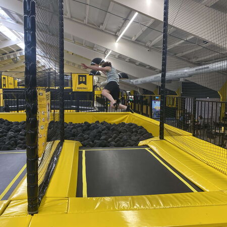 Ein Junge springt fröhlich auf einem Trampolin in einer Spielfläche mit Schaumstoffblöcken | © Name.