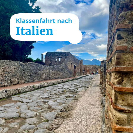 Eine antike Straße in Pompeji führt Schüler auf einer Klassenfahrt durch historische Ruinen in Italien.
