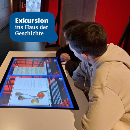 Zwei Personen betrachten interaktive Displays während einer Exkursion im Haus der Geschichte.