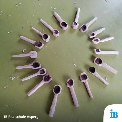Holzlöffel sind kreisförmig auf einem Tisch im Schullandheim der 8a der Realschule arrangiert.