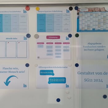 Ein Schaukasten zeigt Informationen zu Schulmitarbeitern, Öffnungszeiten und Bildungsangeboten für 2024.