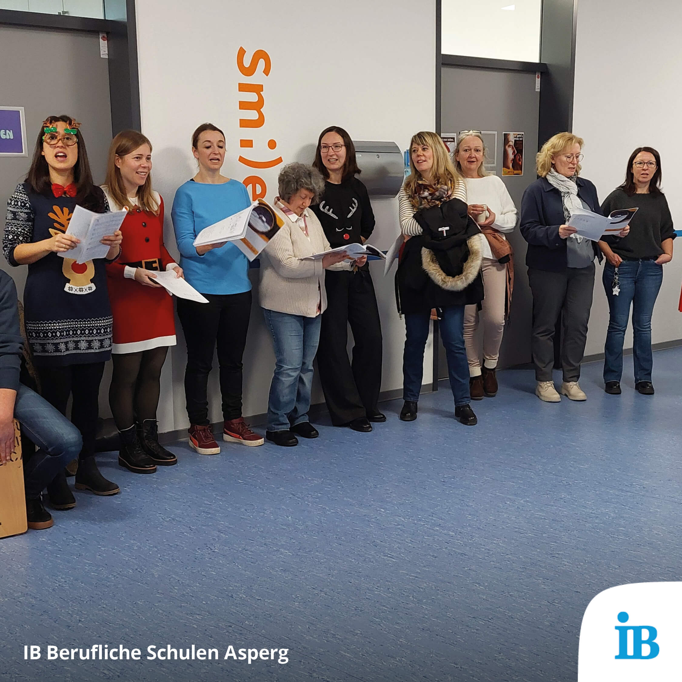 Eine Gruppe von Menschen singt zusammen bei einer Nikolausaktion in einer Schule.