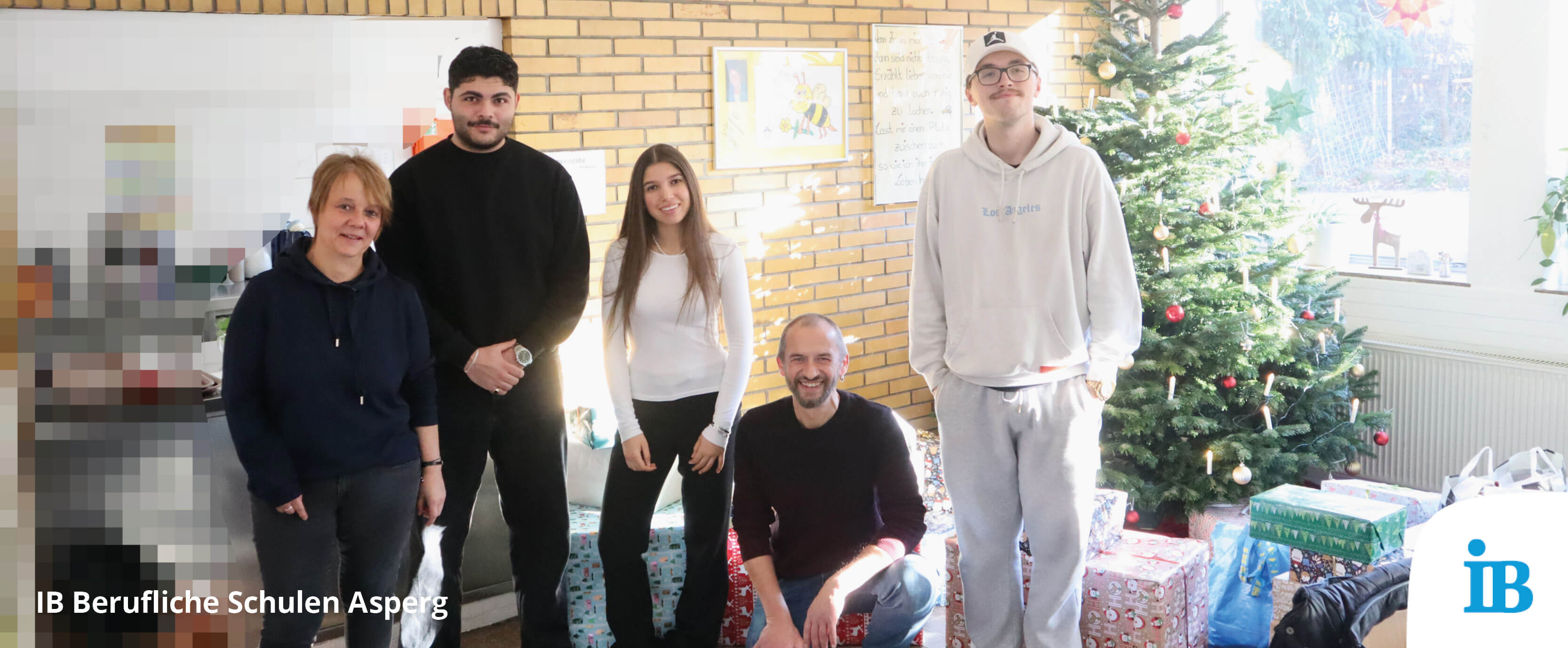 Eine Gruppe von Menschen steht fröhlich vor einem geschmückten Weihnachtsbaum in Stuttgart, umgeben von Geschenken.