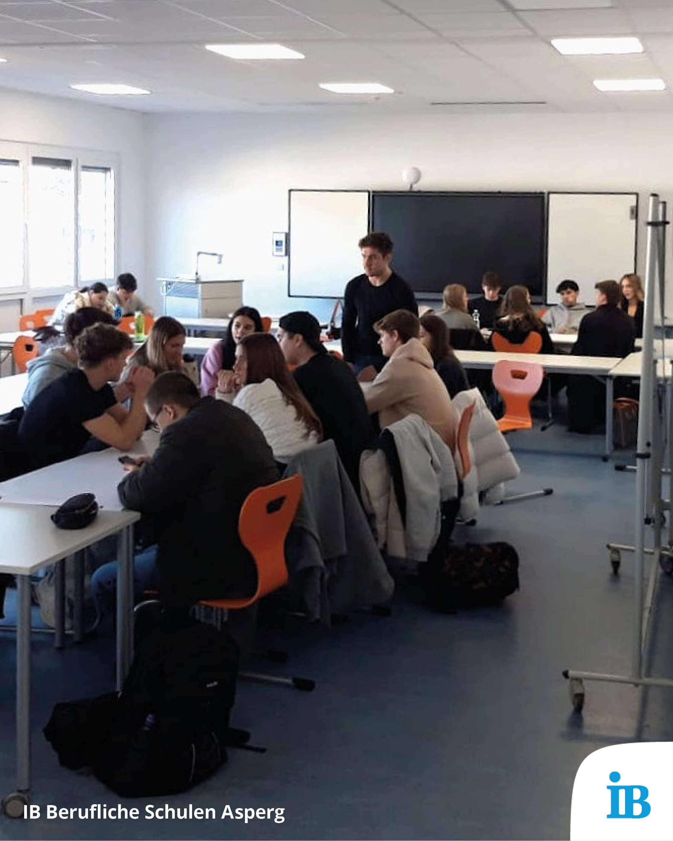 Schüler arbeiten in Gruppen in einem modernen Klassenzimmer der Beruflichen Schulen Asperg an einem Projekt.