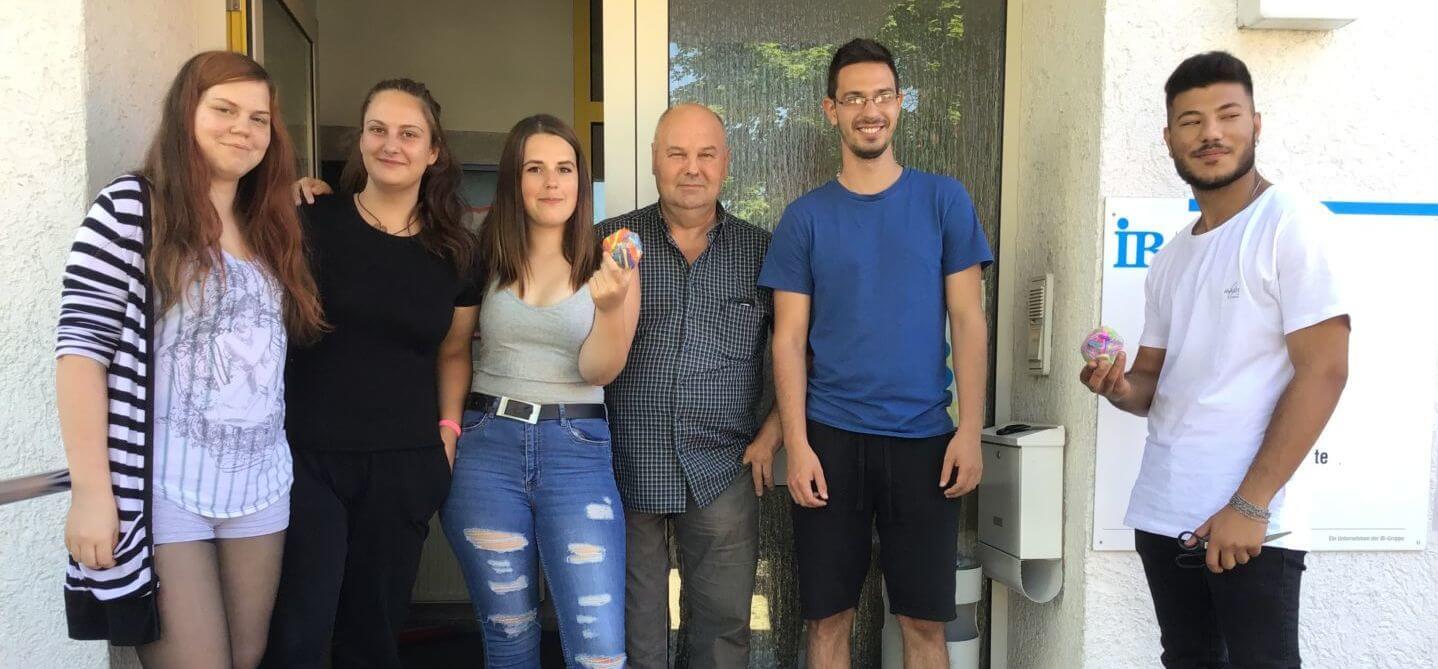 Schüler:innen mit einem Lehrer vor dem Eingang der IB Ehingen