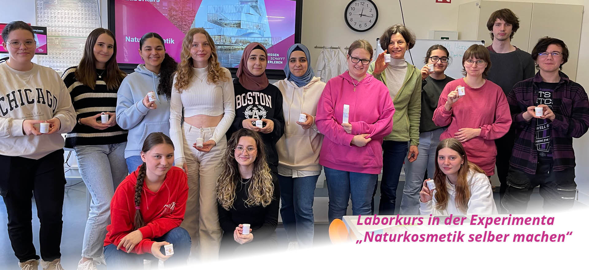 Eine Gruppe von jungen Menschen hält selbstgemachte Naturkosmetik im Laborkurs der Experimenta stolz in die Kamera.
