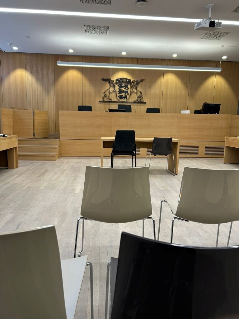 Ein leerer Gerichtssaal mit Holzverkleidung und Stühlen, bereit für die nächste Anhörung im Amtsgericht. | © Name